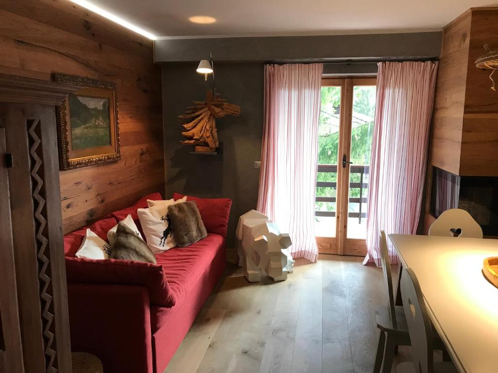 ein Wohnzimmer mit einem roten Sofa und einem Fenster in der Unterkunft APPARTAMENTO SONNE in Ponte di Legno