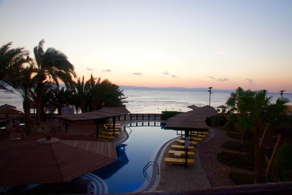 ダハブにあるNesima Resortのプールと海を望むリゾートです。