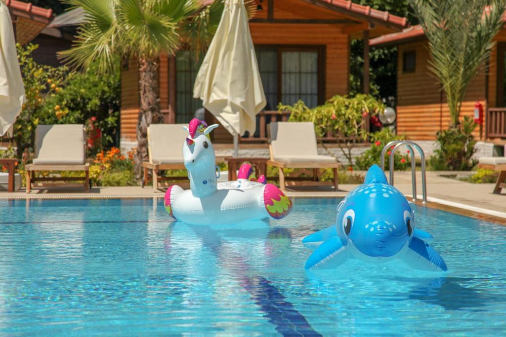 twee opblaasbare dieren in het water in een zwembad bij Dolunay Apart Hotel in Cıralı