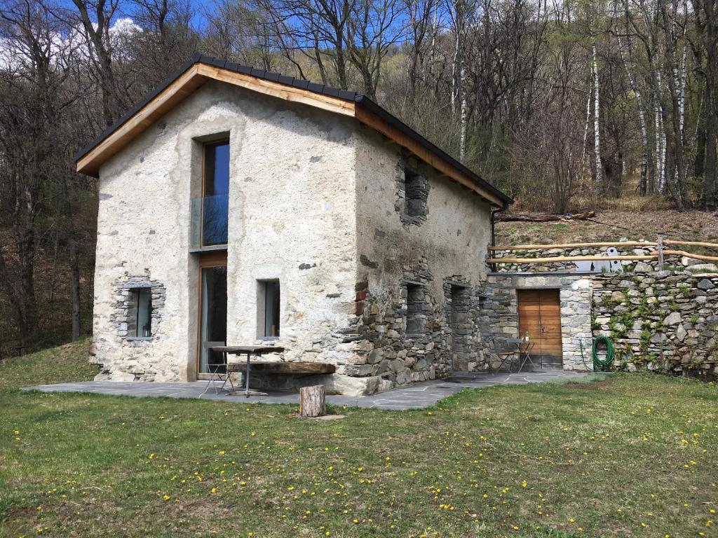 une maison en pierre au milieu d'un champ dans l'établissement Rustico Berlinda, à Bironico