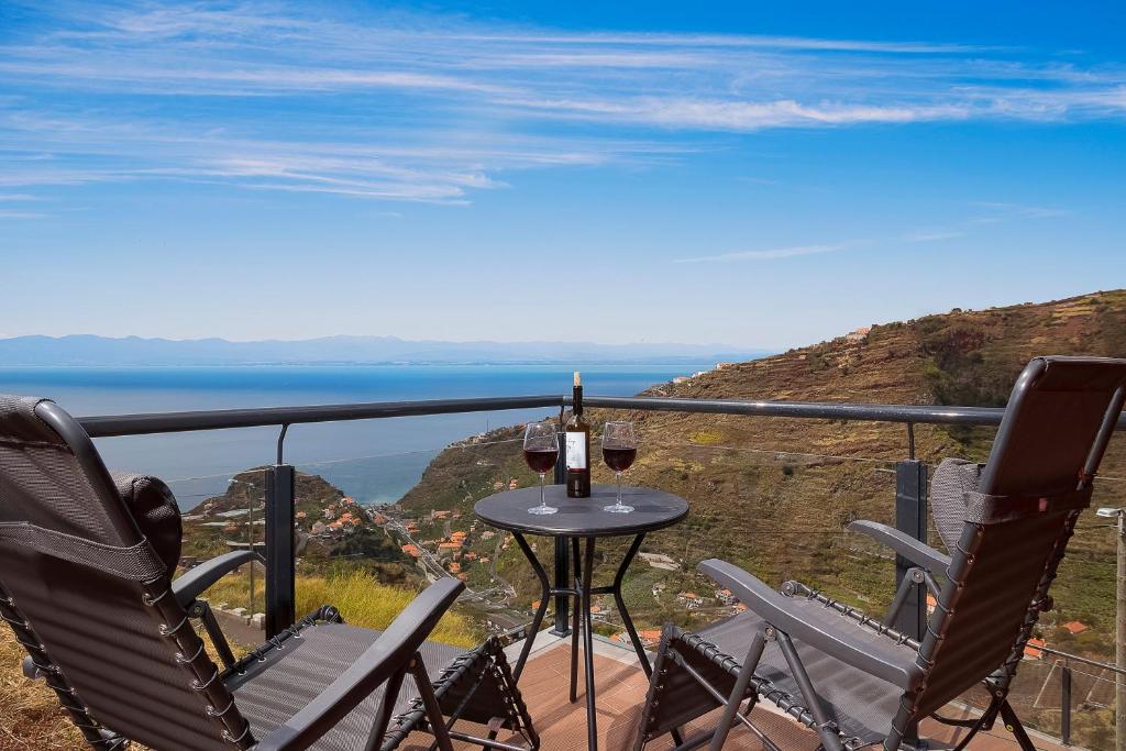 uma mesa e cadeiras numa varanda com vista para o oceano em SEA VIEW LOFT MADEIRA em Ribeira Brava