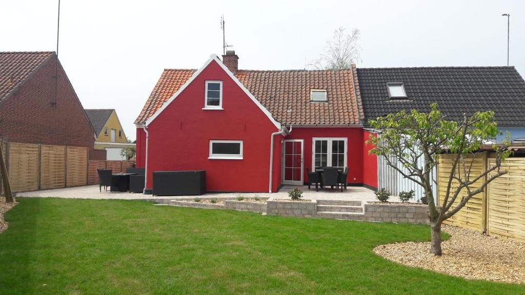 ein rotes Haus mit Rasen davor in der Unterkunft 140m2 Villa in Marstal in Marstal
