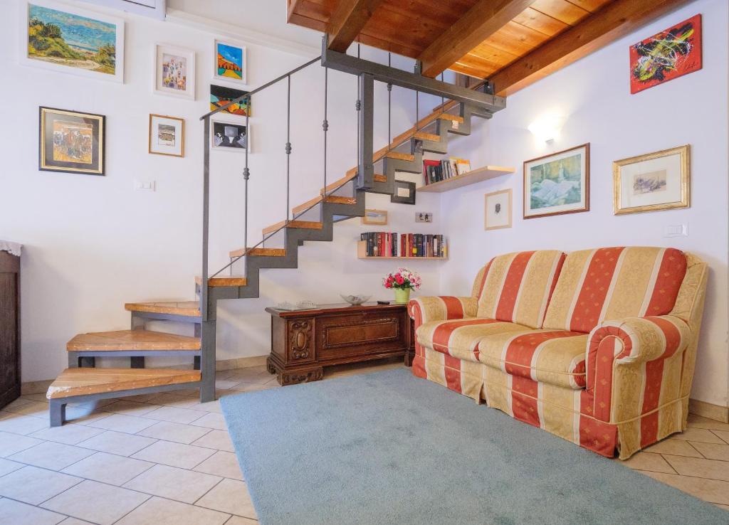 a living room with a couch and a staircase at Casa Snomata in Senigallia