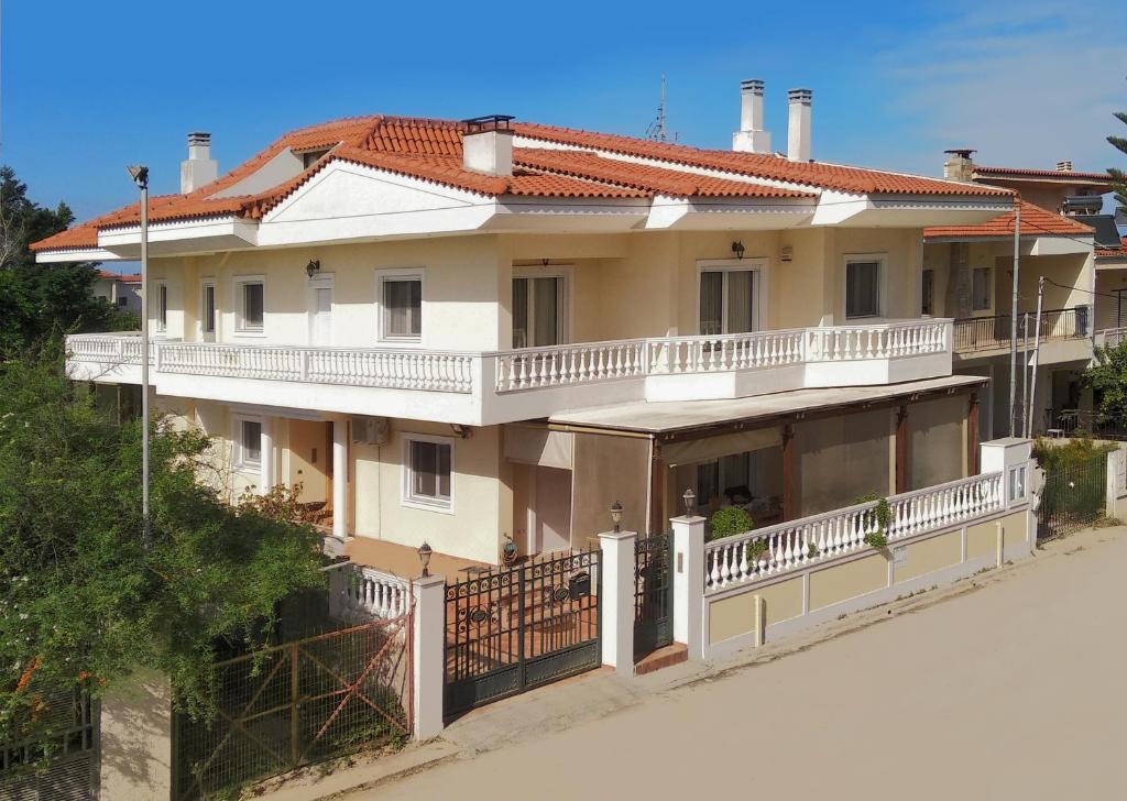 a large white house with a balcony at Villa Elegant in Periyiálion