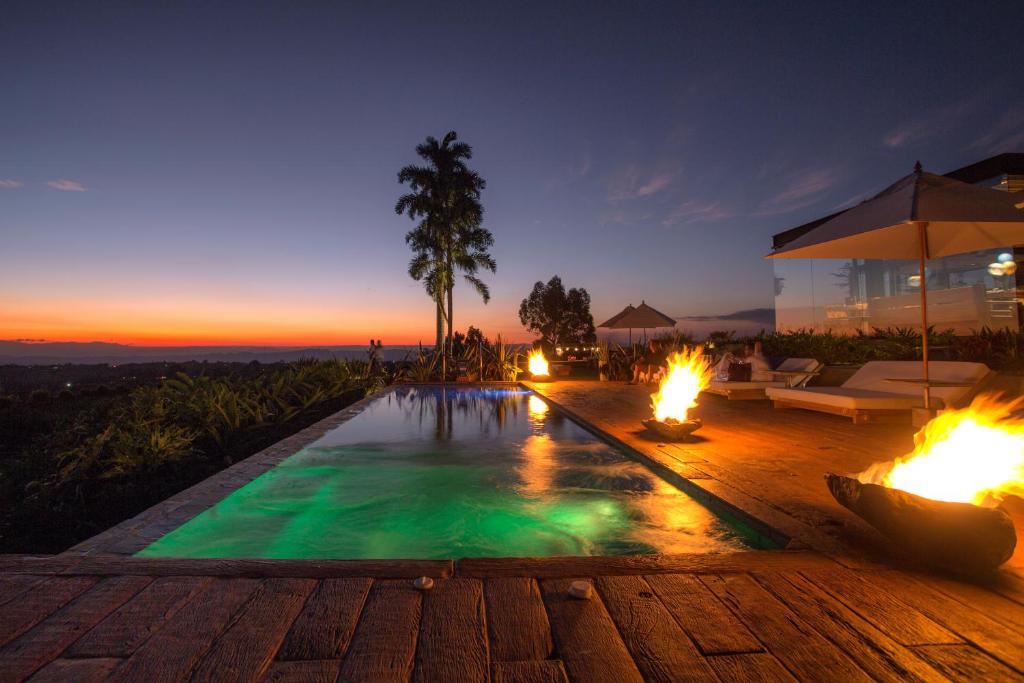 a swimming pool with fire pits in a house at Bio Habitat Hotel in Armenia