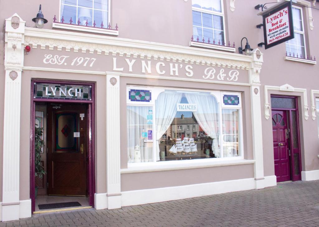 un frente de tienda con un cartel que lee alquileres de lujo en Lynch's en Kilkee