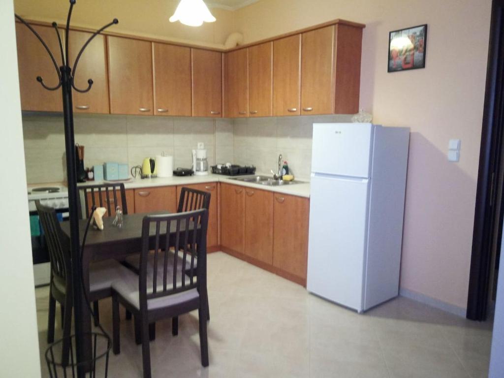 a kitchen with a table and a white refrigerator at Teo's House 1 in Kalabaka