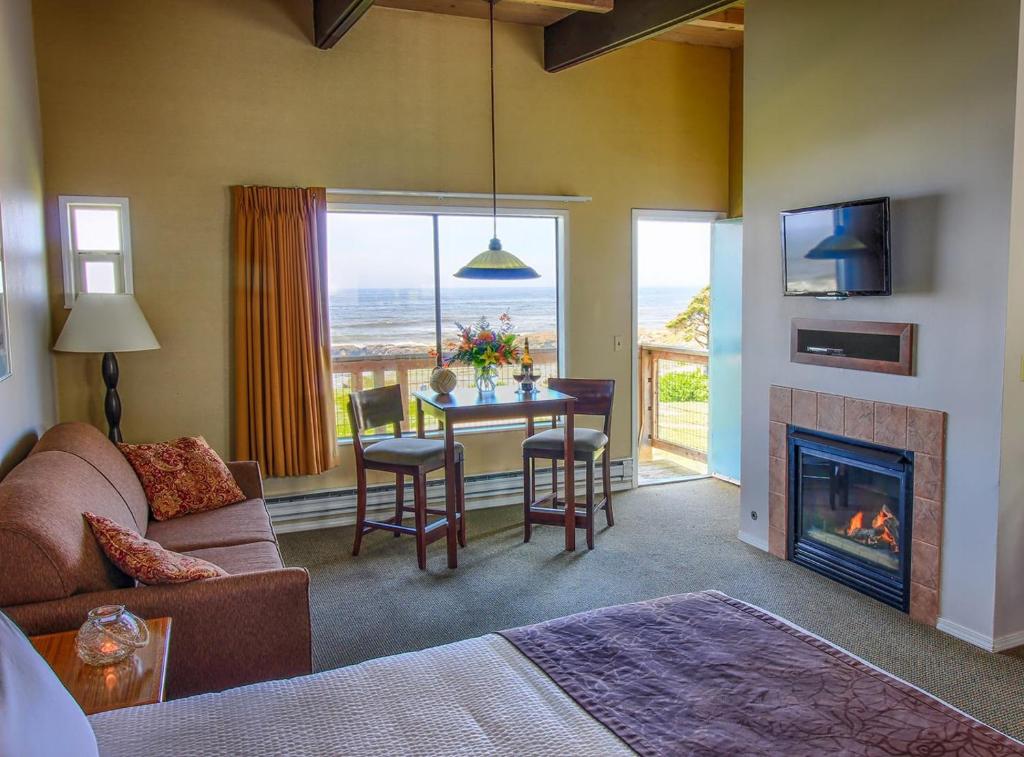 sala de estar con mesa y chimenea en Fireside Motel en Yachats