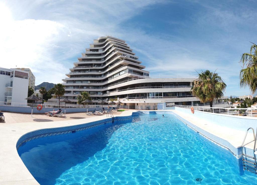 a swimming pool in front of a large building at Cielomar Benalmadena costa in Benalmádena