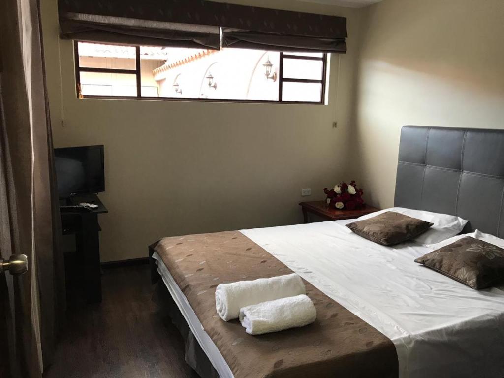 a bedroom with a large bed with two towels on it at Suite Hermano Miguel in Cuenca