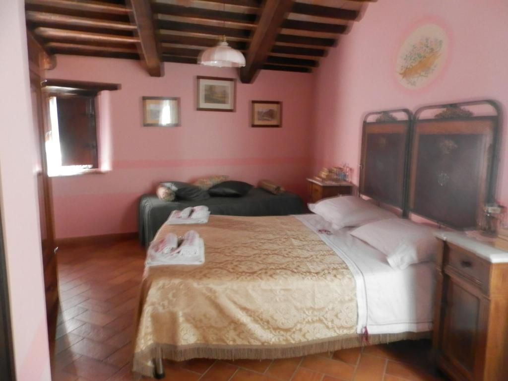 a bedroom with a bed in a room with pink walls at Residenza di Paese Castello del Poggio in Ferentillo