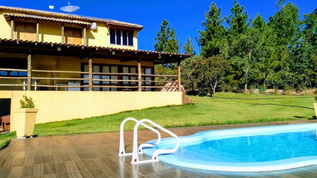 a villa with a swimming pool in front of a house at rancho california in Delfinópolis