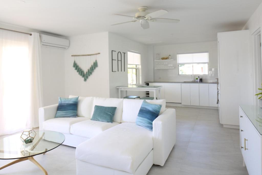 a white living room with a white couch and blue pillows at Sea Glass Villa - Spacious 3 Bed / 2 Bath (Lantana 39) in Saint James