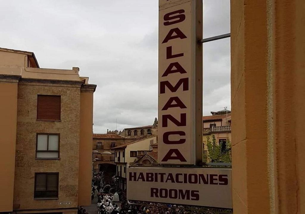 un panneau sur un bâtiment avec un panneau indiquant un hôtel dans l'établissement Pension Salamanca, à Salamanque