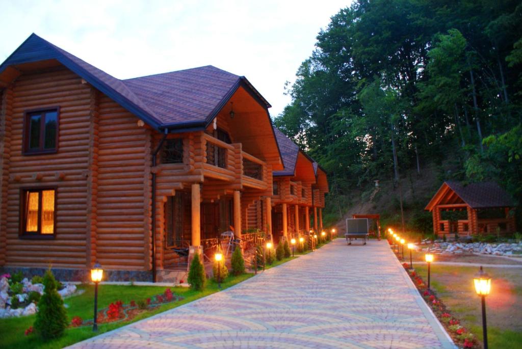 a log cabin with lights in front of it at Oasis Karpat in Polyana