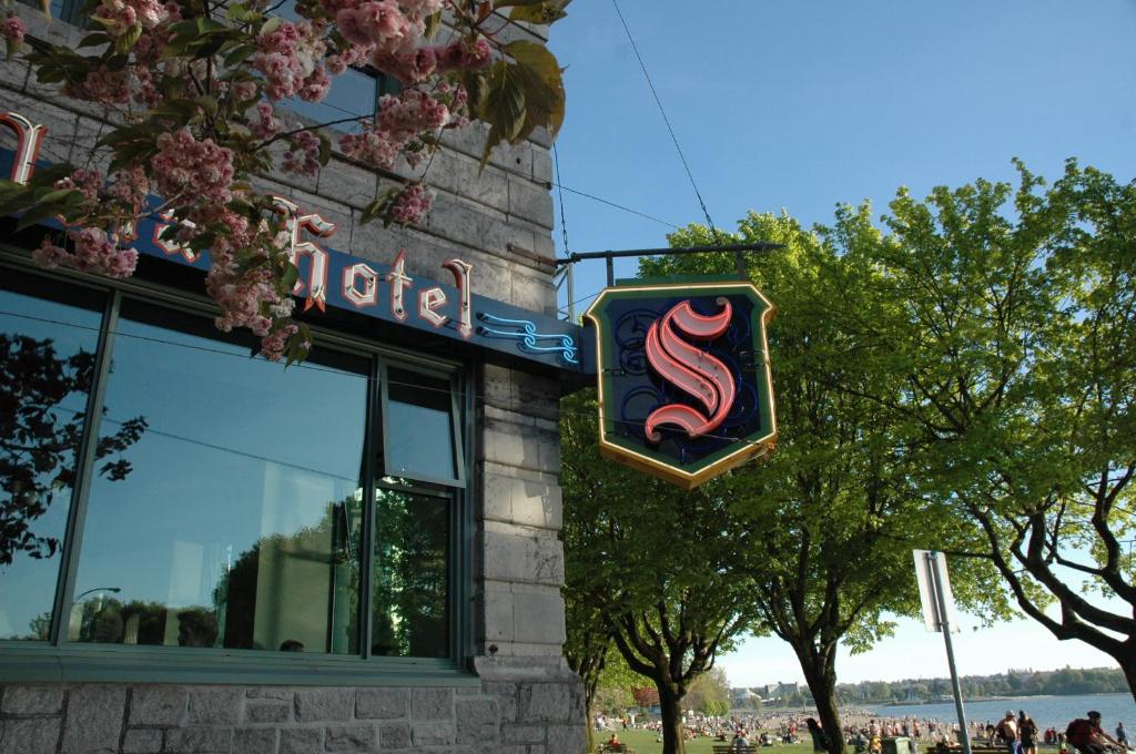 a restaurant with a sign on the side of a building at The Sylvia Hotel in Vancouver