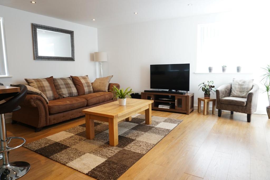 uma sala de estar com um sofá e uma televisão em Ocean Views 4 em Newquay