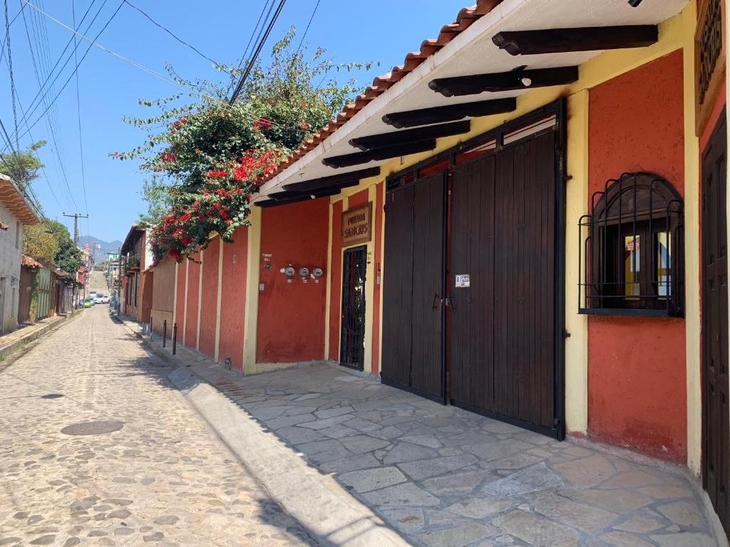 une rue vide avec un bâtiment orange et jaune dans l'établissement Posada Sancris, à San Cristóbal de Las Casas