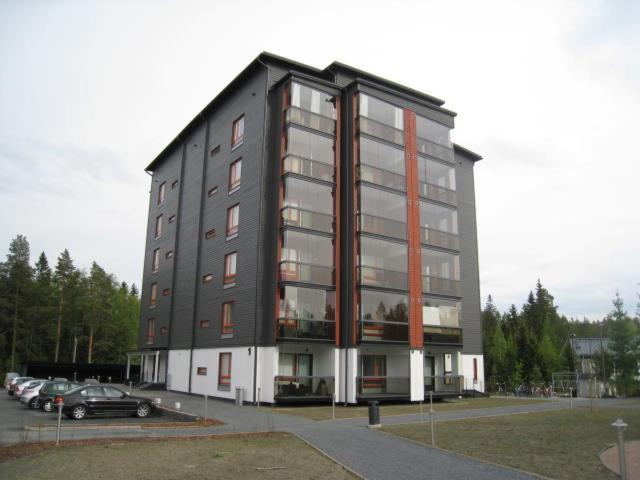 a black building with cars parked in a parking lot at Pirjola in Seinäjoki