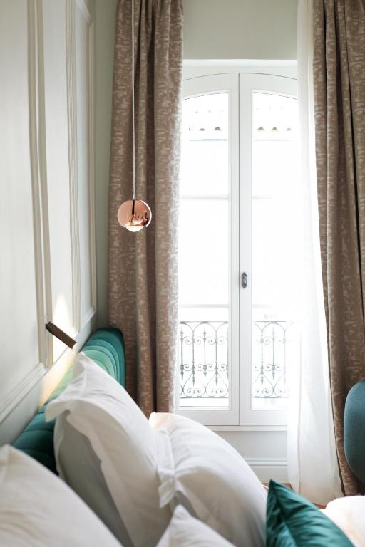a bedroom with a bed and a window at Hôtel Singulier Bordeaux - Boutique Hôtel & Spa Anne Semonin in Bordeaux