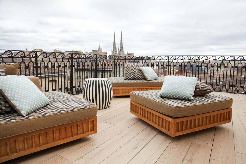 a group of chaises and ottomans on a roof at Hôtel Singulier Bordeaux - Boutique Hôtel & Spa Anne Semonin in Bordeaux