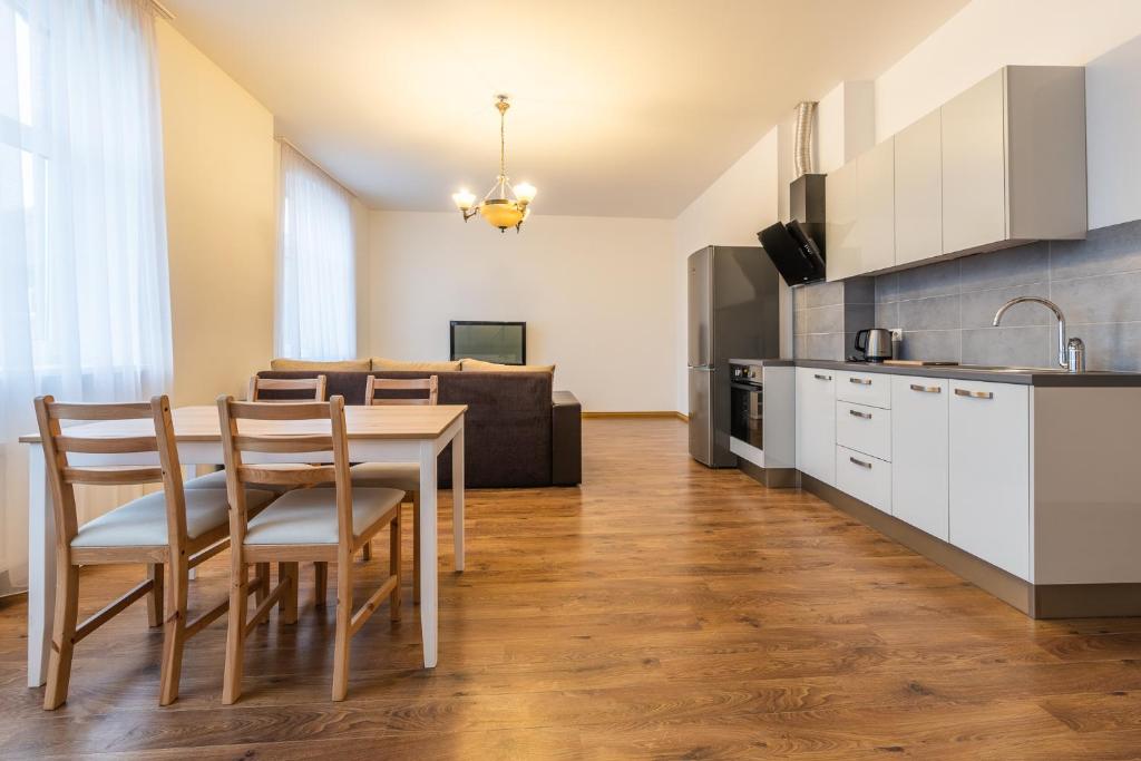 Il comprend une cuisine et un salon avec une table et des chaises. dans l'établissement Old Port, à Liepāja