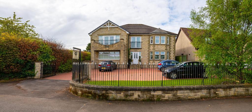 a house with two cars parked in front of it at Springfield Lodge Bed and Breakfast in Stirling