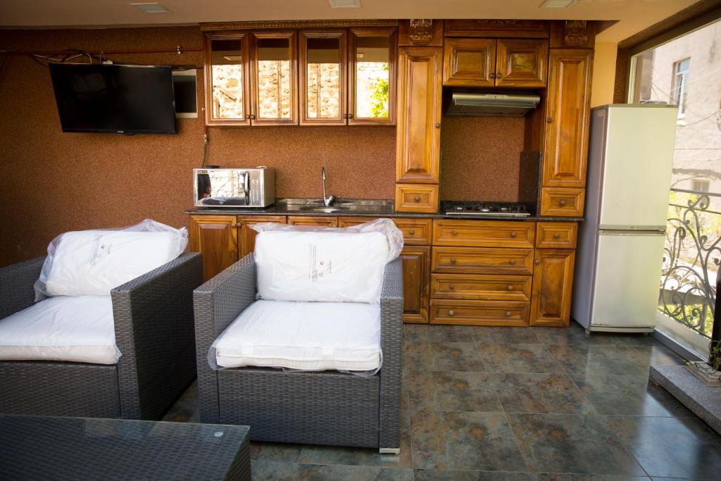 uma cozinha com 2 cadeiras e um frigorífico em Hotel Black Sea House em Batumi