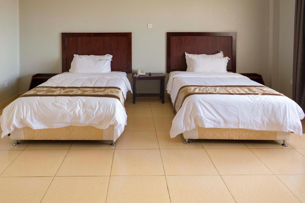 dos camas sentadas una al lado de la otra en una habitación en Easy View Hotel Mbarara, en Mbarara