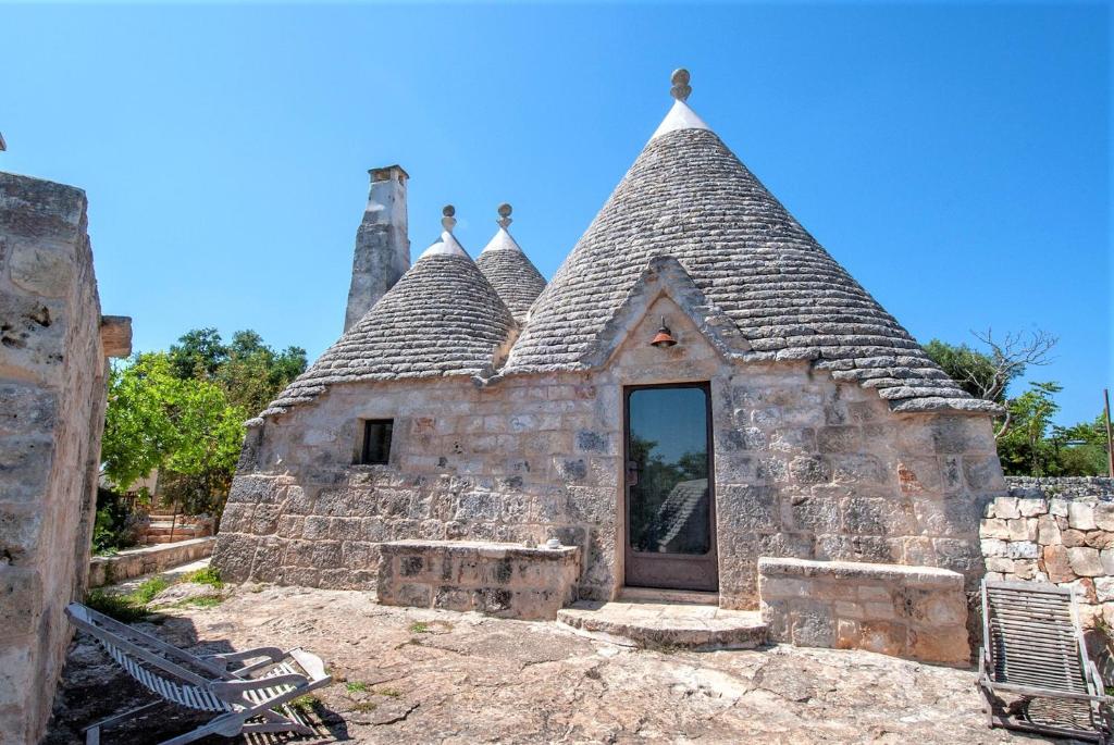 una antigua casa de piedra con techo en Casa Vacanze Riposo Del Vento, en Cisternino