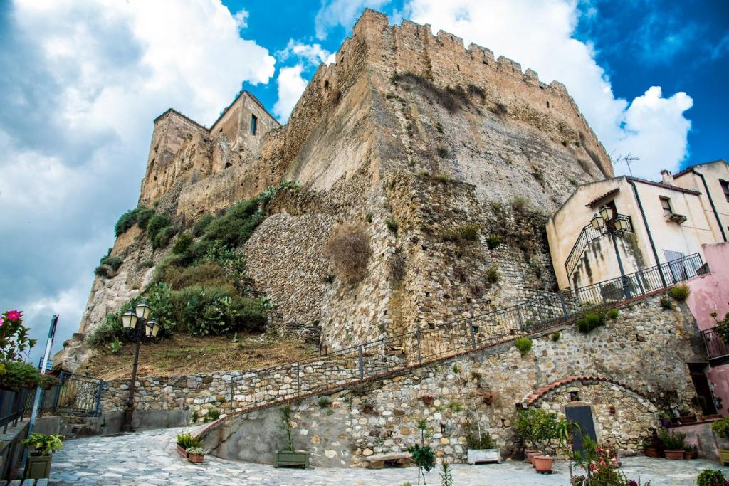 a large stone mountain with plants on it at Casa castello in Rocca Imperiale