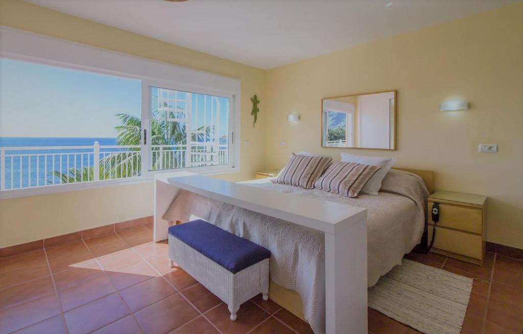 ロス・レアレホスにあるVilla in protected space in front of the seaのベッドルーム1室(ベッド1台、大きな窓付)