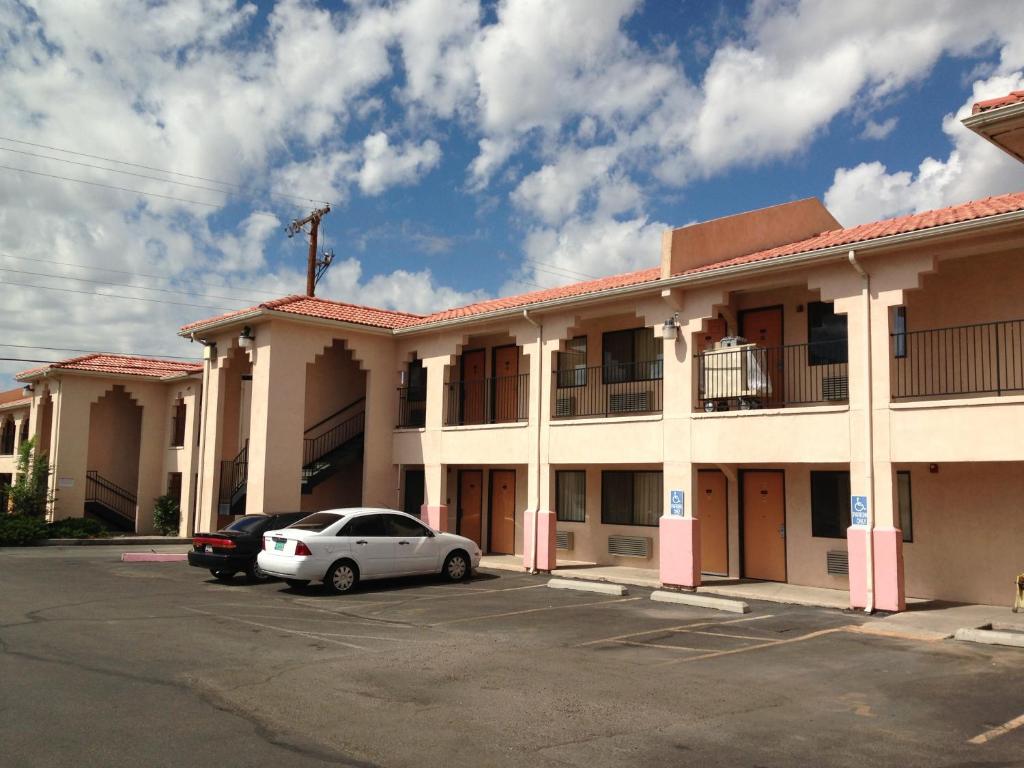 un coche blanco estacionado frente a un edificio en Luxury Inn, en Albuquerque