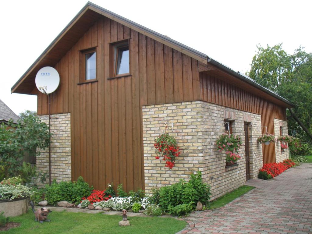 un edificio con flores a un lado. en Pulkvedis Guest House, en Ventspils