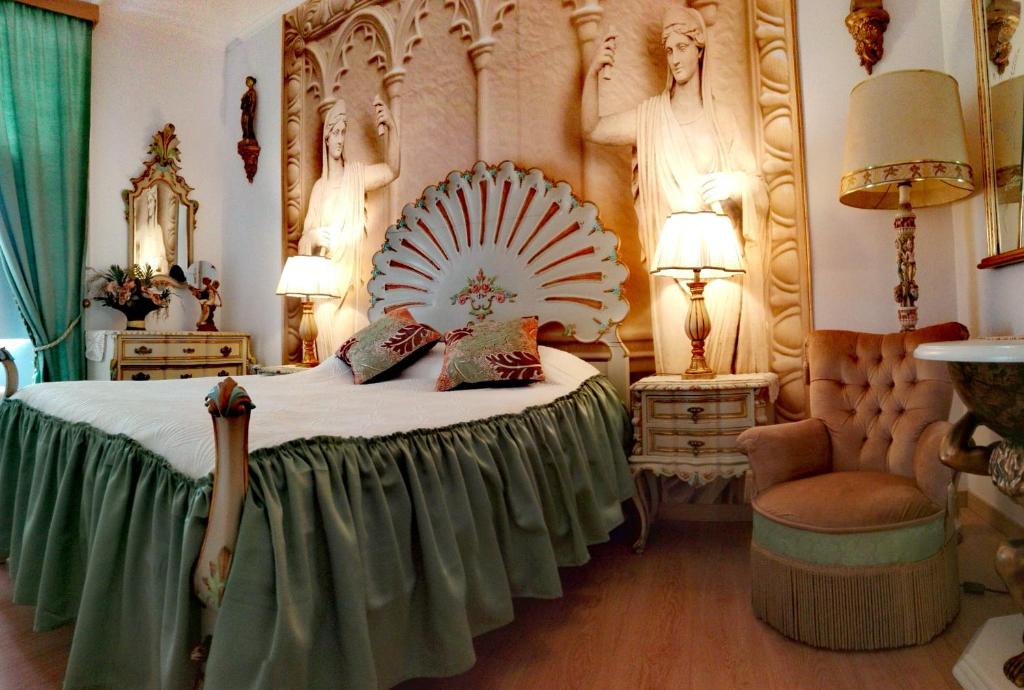 a bedroom with a large bed with a fancy headboard at Império Romano Guest House in Beja