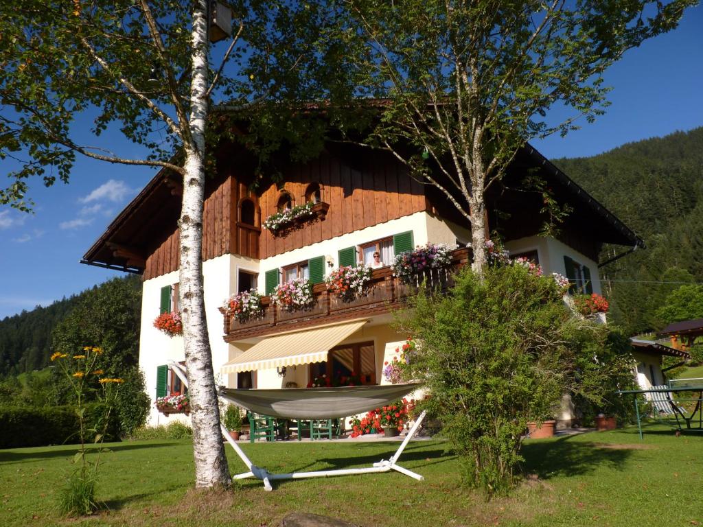 a house with a hammock in front of it at Ferienwohnung Inge Gapp in Gosau