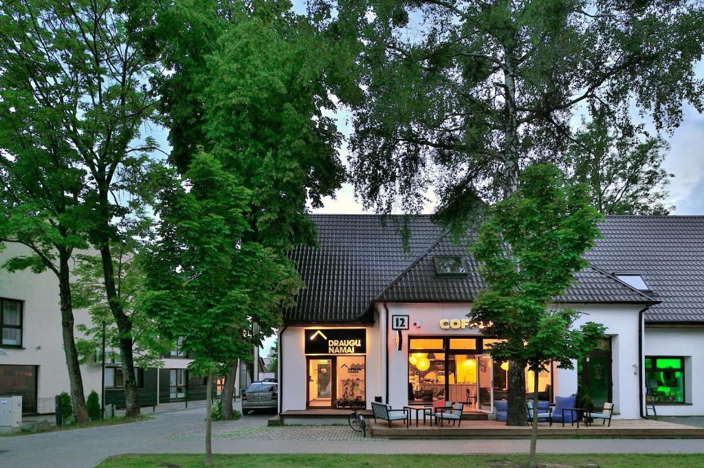 a store with tables and chairs in front of a building at Draugų namai in Druskininkai