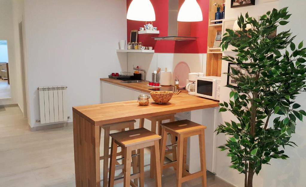 cocina con mesa con taburetes y microondas en La Casa de Cayetana AT-47-44, en Valladolid