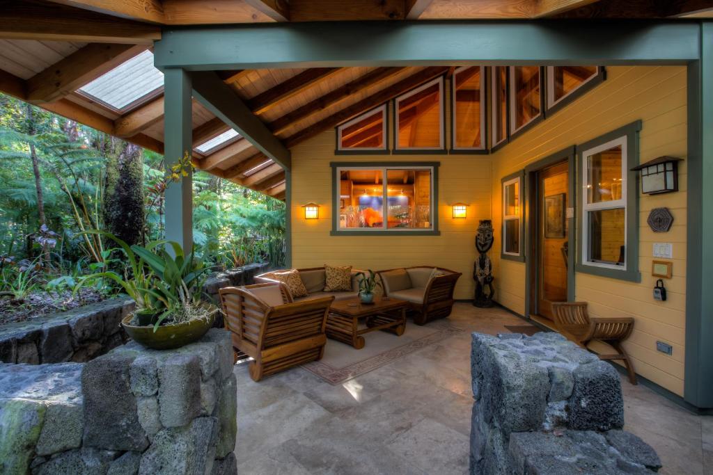 an outdoor patio with a couch and a table at Volcano Mist Cottage in Volcano