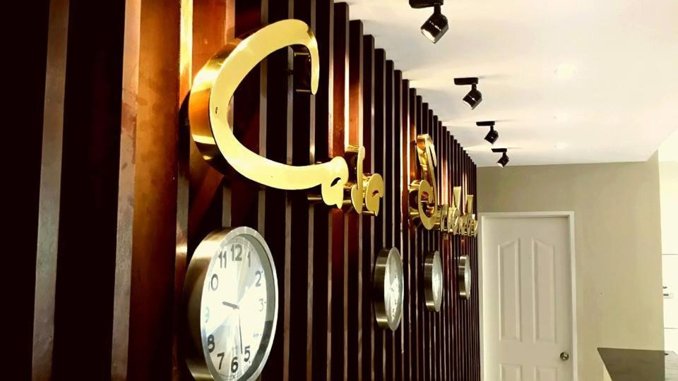 un reloj en una pared con una letra c en ella en Casa Saudade Condotels and Transient Rooms en Olongapo