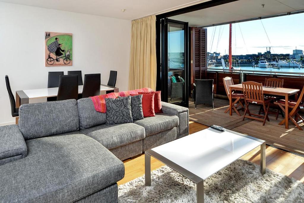 a living room with a couch and a table at QV Stylish Waterfront Apartment - 317 in Auckland