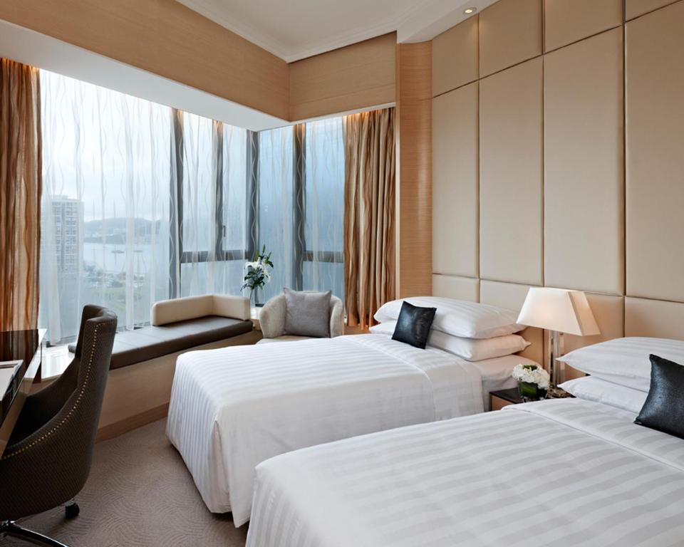 a hotel room with two beds and a desk at Dorsett Kwun Tong, Hong Kong in Hong Kong