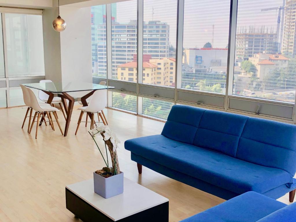 sala de estar con sofá azul y mesa en Two Room Suite in the Best Location of Santa Fe, en Ciudad de México