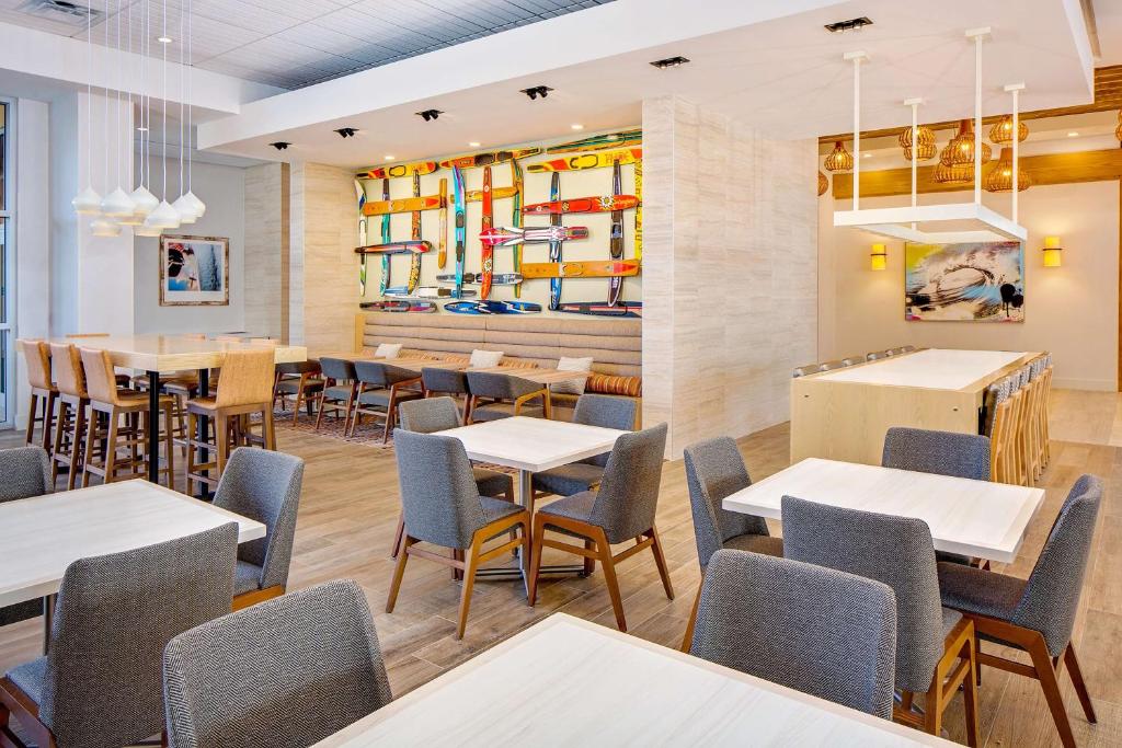 a restaurant with tables, chairs, and tables in it at Hyatt House across from Universal Orlando Resort in Orlando