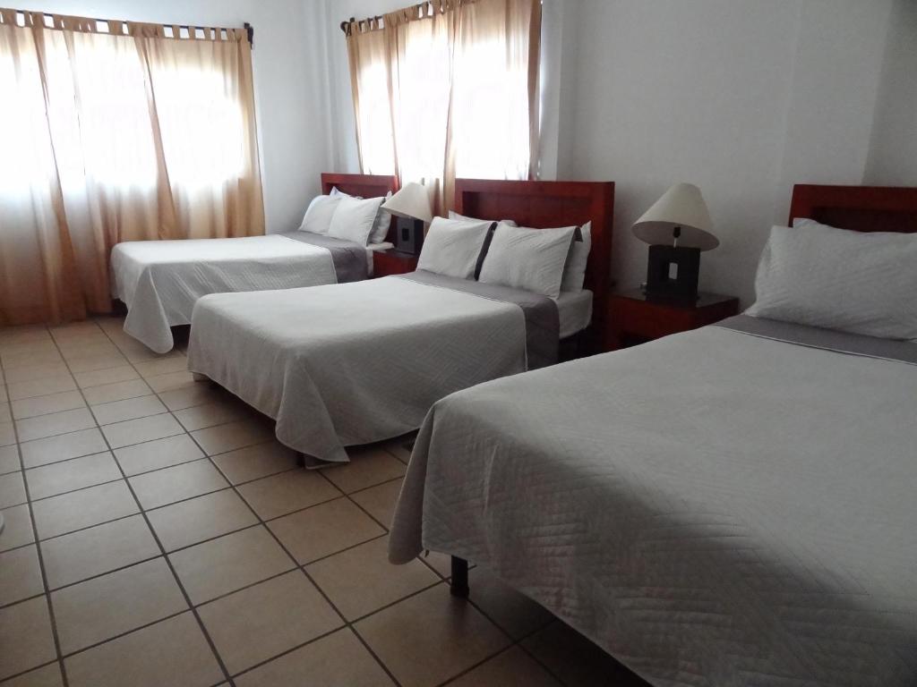 een hotelkamer met 2 bedden met witte lakens bij Hotel San Miguel Penjamo in Pénjamo