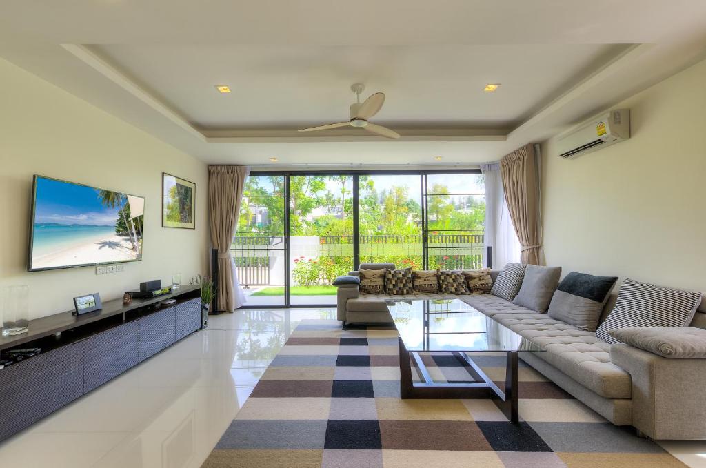 uma sala de estar com um sofá e uma televisão em 4 bdr villa with cinema in Laguna, 800 m to beach #157 em Praia de Bang Tao