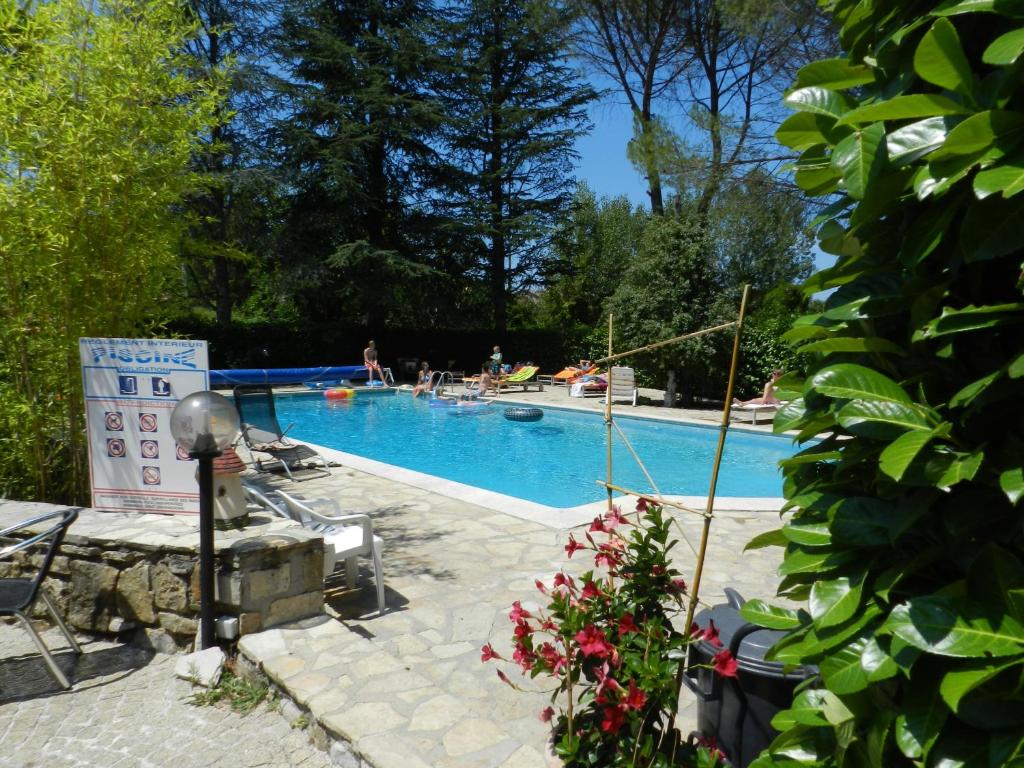 - une piscine avec des personnes à l'arrière-plan dans l'établissement Domaine de La Tour, à Salavas