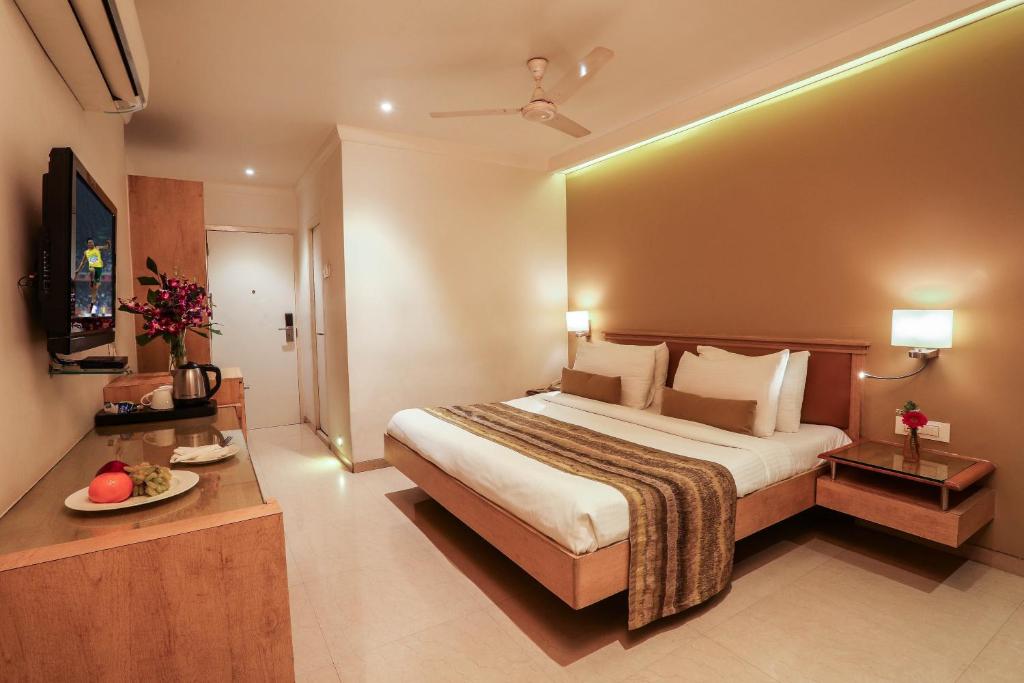 Pokój hotelowy z dużym łóżkiem i telewizorem w obiekcie Hotel Suncity Apollo, Colaba w Bombaju