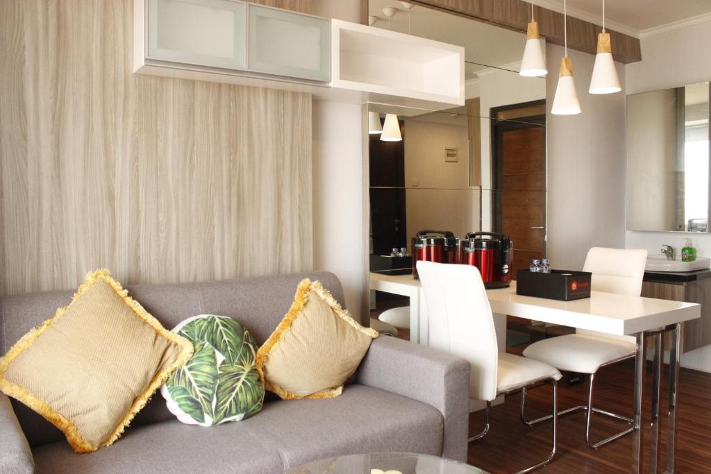 a living room with a couch and a table at Gorgeous 2BR Apartment at Gateway Pasteur near Exit Toll By Travelio in Bandung