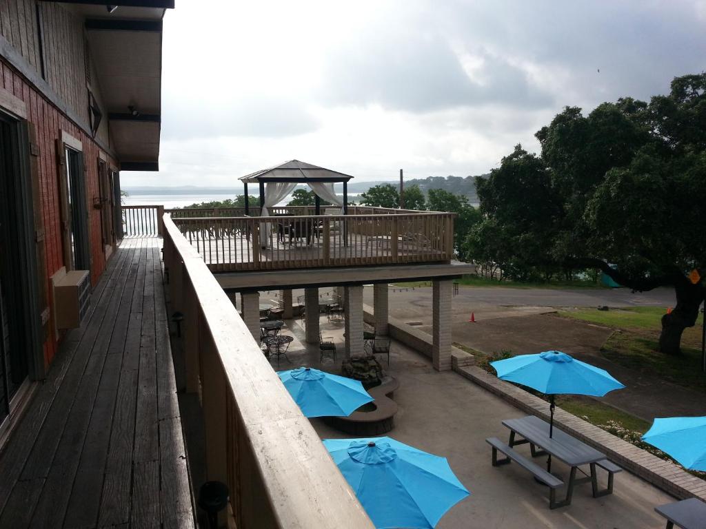 a deck with tables and blue umbrellas at Lodge At Turkey Cove in Canyon Lake